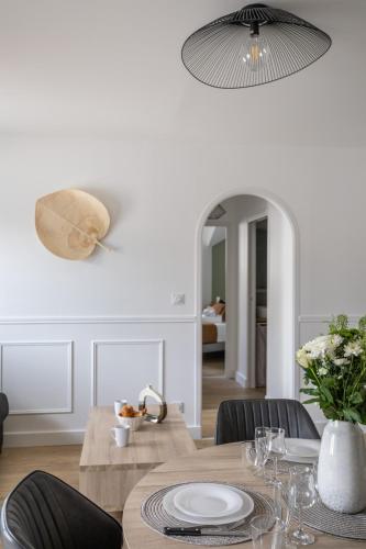 une salle à manger avec une table, des chaises et une lampe dans l'établissement L'EUCALYPTUS - Charmant appartement de 52m2, à Dinard