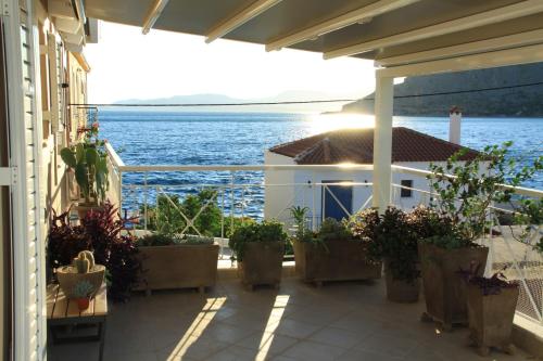 a balcony with potted plants on a building with the ocean at Asteri Apartments Mytikas 2-Bedroom Penthouse 360 Views in Mýtikas