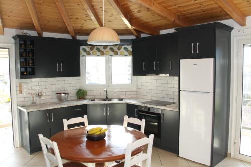 een keuken met een tafel en een witte koelkast bij Asteri Apartments Mytikas 2-Bedroom Penthouse 360 Views in Mýtikas
