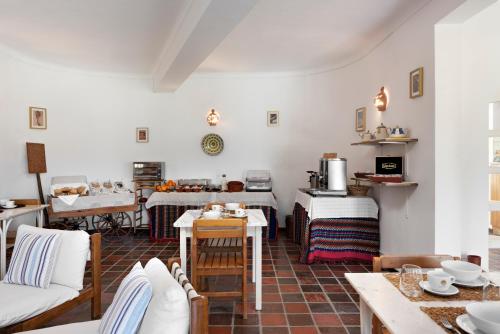a living room with white walls and a table and chairs at Quinta Do Moinho De Vento - Duna Parque Group in Vila Nova de Milfontes