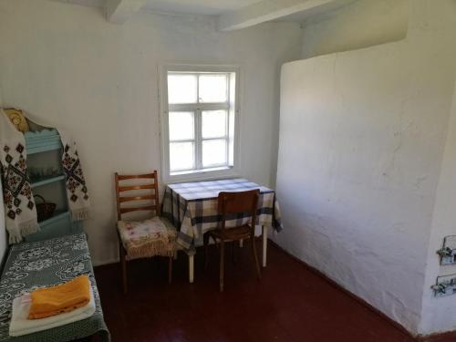 a room with a table and chairs and a window at У Катерини in Dvozhets