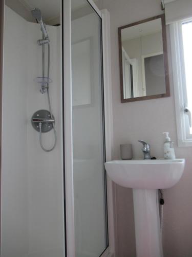 a white bathroom with a sink and a shower at Chichester Lakeside Self-Catering Holiday Home in Chichester