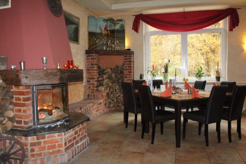 uma sala de jantar com uma mesa e uma lareira em Jägerhof Ostsee em Holm