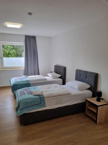 two beds in a room with a window at Twitch Appartments in Achim
