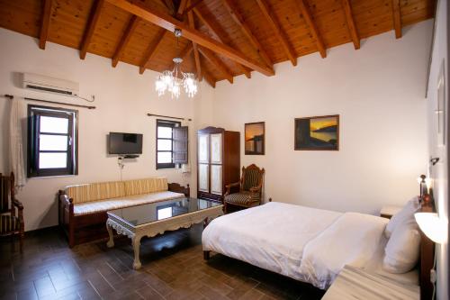 a bedroom with a bed and a couch and a table at Traditional Apartments Plagiaki in Neon Oitilon