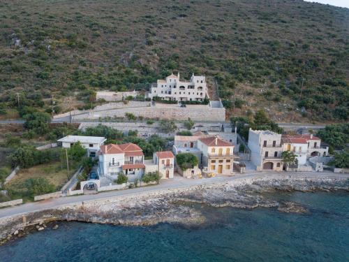 a group of houses on a hill next to the water at Traditional Apartments Plagiaki in Neon Oitilon