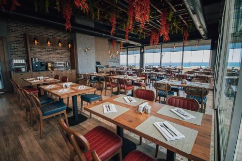 Un restaurante con mesas y sillas de madera y ventanas. en Panagia Premier Trabzon, en Trabzon