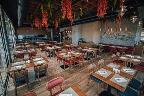 Un restaurante vacío con mesas y sillas de madera. en Panagia Premier Trabzon, en Trabzon