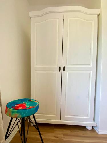 a stool and a white cabinet in a room at Pension Rohrer am Murradweg - Ehrenhausen an der Weinstrasse in Ehrenhausen