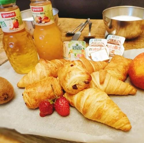 una mesa con cruasanes y fresas en una tabla de cortar en Vittoria Immobilier 8 -Vue Mer - Terrasse - chèques vacances acceptés, en La Grande-Motte