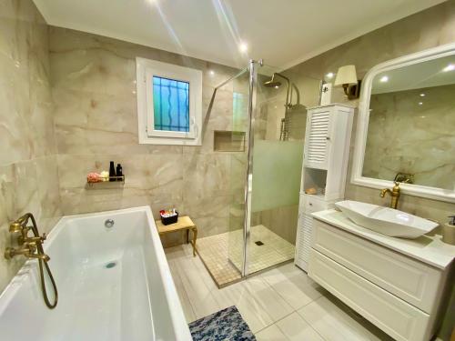 une salle de bain avec une baignoire, un lavabo et une douche dans l'établissement Villa Canarias, à Saint-Jeannet