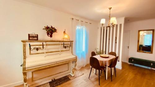 um quarto com um piano, uma mesa e cadeiras em Villa Canarias em Saint-Jeannet