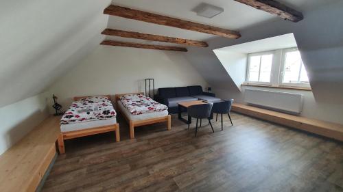 um quarto com duas camas, uma mesa e um sofá em V Jeseníku em Jeseník