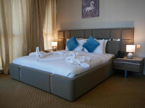 Una cama grande en una habitación de hotel con toallas. en Panorama Hotel Kuwait en Kuwait