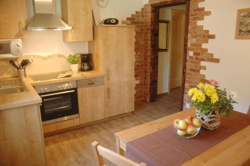 a kitchen with a table with a bowl of fruit on it at Haus Sonnenruh in Mittenwald