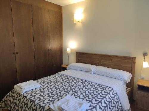 a bedroom with a bed with two towels on it at Los Altos de Escarrilla - tucasaenlospirineos in Escarrilla