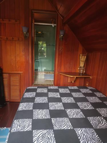 a bedroom with a black and white quilt on a bed at Hospedaria Bela Vista do Vale in Lumiar