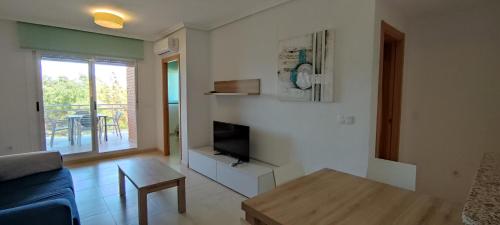 a living room with a couch and a tv and a table at ACV - Playa Dorada -1ª Linea planta 3 norte in Oropesa del Mar