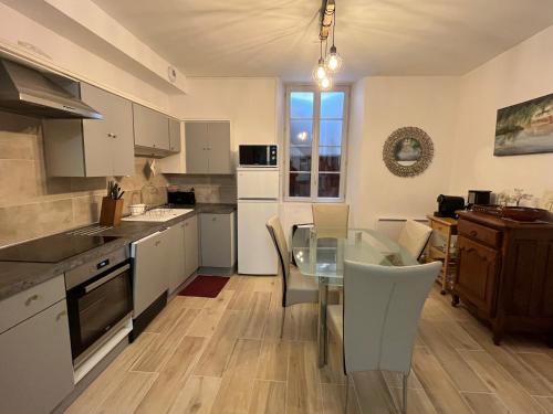 a kitchen with a glass table and a dining room at Le Logis - lescapade-medievale Sarlat in Sarlat-la-Canéda