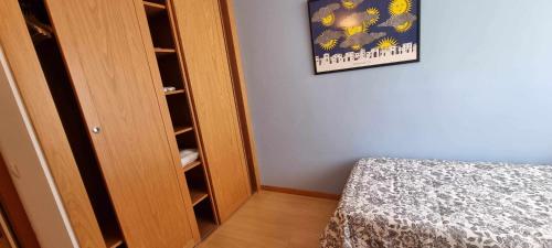 1 dormitorio con armario, cama y una foto en Apartamento Vacacional Roma en Barro de Llanes