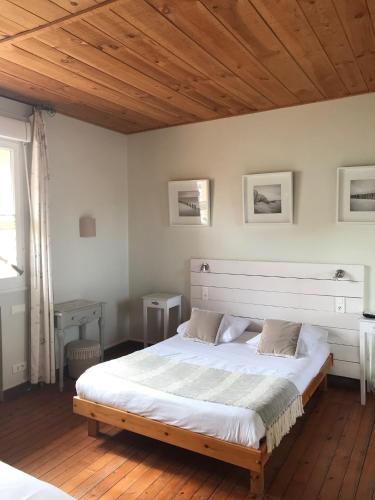 une chambre avec un grand lit avec un plafond en bois dans l'établissement Hôtel de la Tour, à Les Sables-dʼOlonne