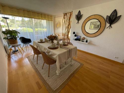 a dining room with a table and a mirror at Saint Tropez Spacieux Appartement La Florida in Saint-Tropez
