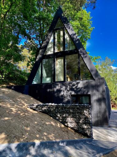 a house with a triangular roof with windows at Domki MODERN Jezioro Nyskie in Nysa