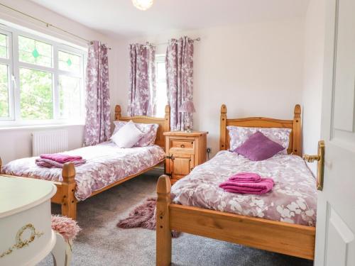 a bedroom with two beds and a window at Pencraig in Colwyn Bay