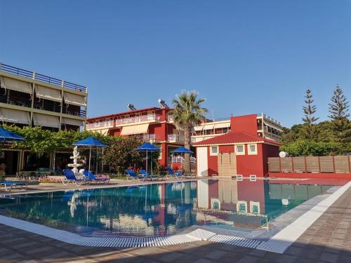 a swimming pool with chairs and a red building at Brati - Arcoudi Hotel in Arkoudi