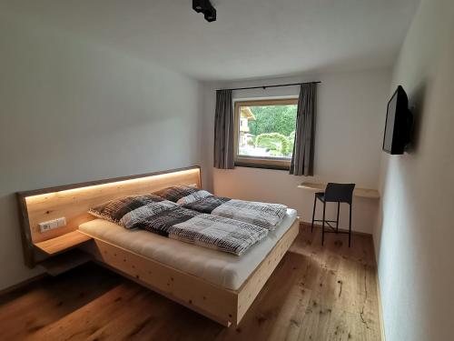 1 dormitorio con cama, escritorio y ventana en Ferienwohnung Lotterhof, en Heinfels