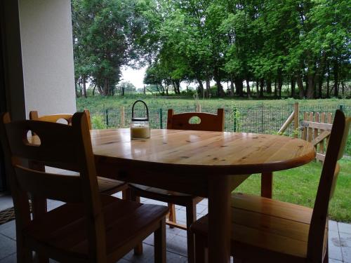- une table en bois avec des chaises et une boisson dans l'établissement Séjour inoubliable en baie de SOMME, logement neuf, à Saint-Valery-sur-Somme