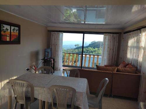 a dining room with a table and chairs and a balcony at Un lugar para descansar in Palestina