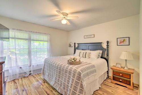 a bedroom with a bed with a ceiling fan and a window at Cozy Auburn Retreat with Hot Tub - Walk to Lake in Auburn