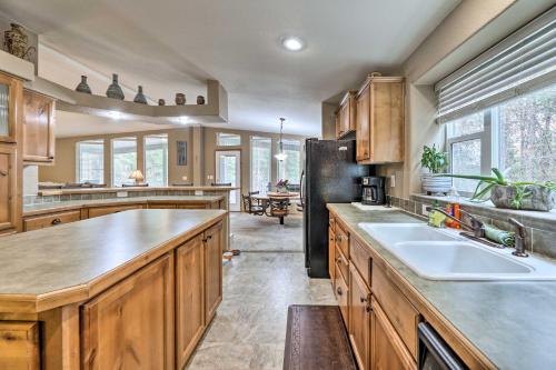 a kitchen with wooden cabinets and a black refrigerator at Rustic Escape with Deck, Hot Tub and Mountain Views in Irwin