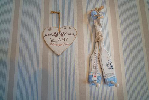 um coração de madeira pendurado numa parede com um par de escovas de dentes em Pokoje gościnne Angela em Jastarnia