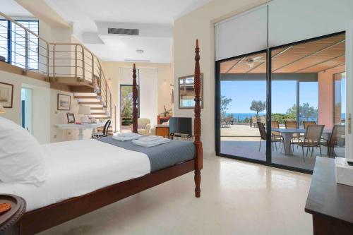 a bedroom with a bed and a view of the ocean at Black Diamond Beachfront Pool Villa Pasithea in Sounio, Athens in Sounio