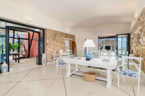 a living room with a white table and chairs at Black Diamond Beachfront Pool Villa Pasithea in Sounio, Athens in Sounio