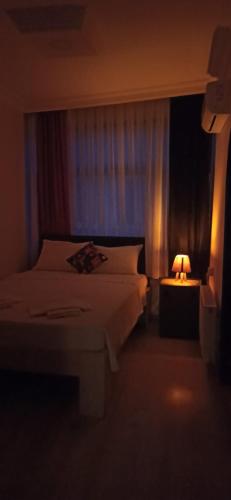 a bedroom with a bed and a lamp on a table at moonlight (AY IŞIĞI ) in Canakkale