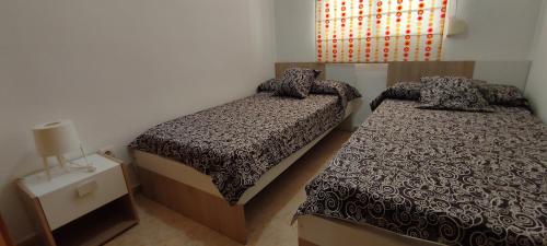 a small bedroom with two beds and a window at ACV - Playa Dorada -1ª Linea planta 3 norte in Oropesa del Mar