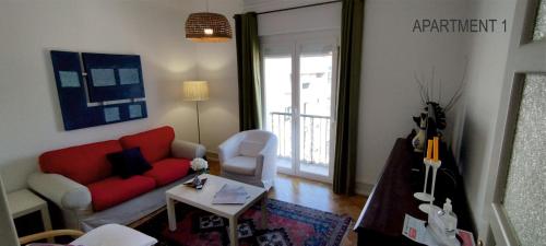 sala de estar con sofá rojo y mesa en Charming Family Apartment, en Lisboa