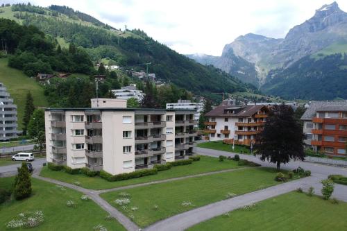 an apartment complex in a village with mountains in the background at Apartment nearby Titlis Station in Engelberg
