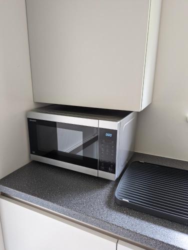a microwave oven sitting on a counter in a kitchen at Unique, Spacious, Self-Built Eco Home with huge garden and movie room in Andover