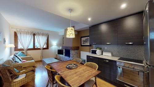eine Küche und ein Wohnzimmer mit einem Tisch und einem Sofa in der Unterkunft Los Altos de Escarrilla - tucasaenlospirineos in Escarrilla