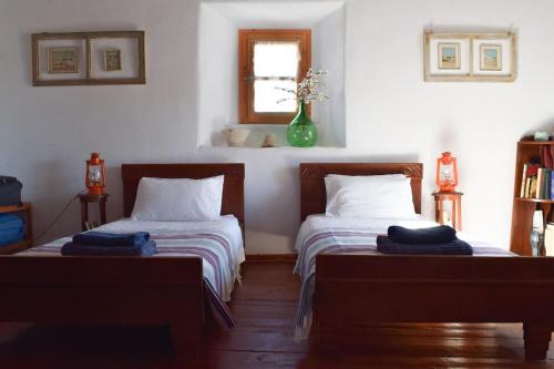 1 dormitorio con 2 camas y ventana en Το πάνω σπίτι της Μαριάνθης, en Márpissa