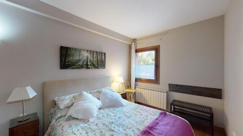 a bedroom with a bed with two pillows on it at Los Altos de Escarrilla - tucasaenlospirineos in Escarrilla