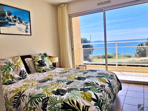 a bedroom with a bed and a large window at Résidence Les Sanguinaires - T2 N°16 - Vue Mer in Ajaccio