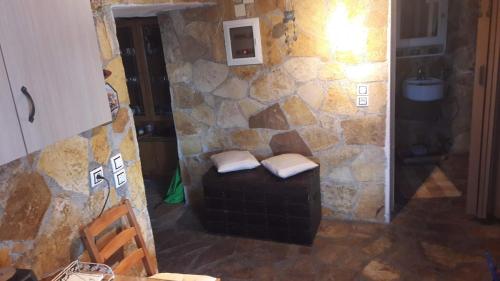 a living room with a stone wall and a couch at Maggie's Traditional home in Pylos