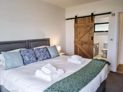 um quarto com uma cama grande e toalhas em 16 - 3 Bedroom Cottage - LP em Pistyll