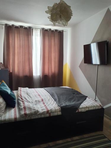 a bedroom with a bed and a window with curtains at Arsan home in Cluj-Napoca
