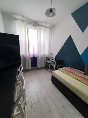 a bedroom with a bed and a desk and a table at Arsan home in Cluj-Napoca